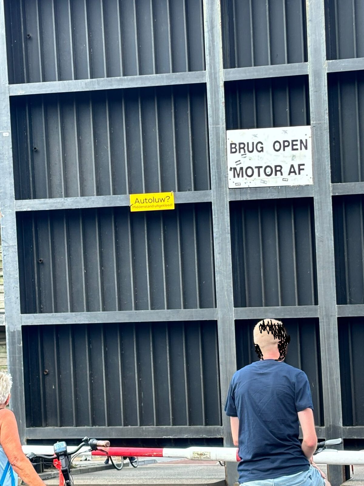 Protestbordje 'Autoluw? Middenstand uitgekleed!' onder de Lemmerbrug Sneek. © BREKT.NL